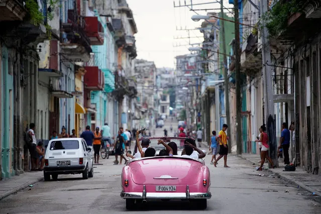 Tourists ride a vintage car in Havana, Cuba, June 11, 2018. (Photo by Alexandre Meneghini/Reuters)