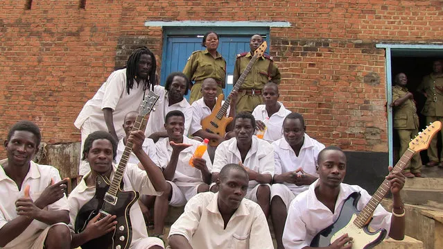 In this photo taken August 23, 2014 and supplied by the Zomba Prison Project, members of the Zomba Prison group pose for a photograph with prison gurads at the Zomba Prison, in southern Malawi. The gentle chorus of maximum security prisoners singing over guitar chords has earned Malawi its first Grammy nomination making history in the impoverished African nation. (Photo by Marilena Delli/Zomba Prison Project via AP Photo)