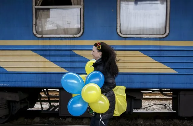 A relative of a Ukrainian serviceman, who took part in fights with pro-Russian rebels in the eastern regions, runs along a train as he arrives at a railway station in Kiev, Ukraine, September 9, 2015. (Photo by Gleb Garanich/Reuters)