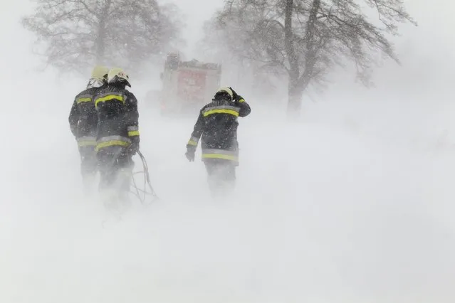 Firemen are on their way to salvage a motorist stranded by a blizzard on a road near Zalaszentbalazs, 214 kms southwest of Budapest, Hungary, Sunday, February 8, 2015. (Photo by Gyorgy Varga/AP Photo/MTI)