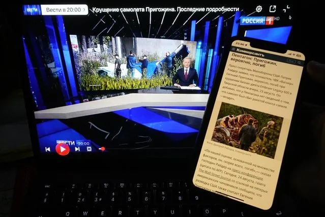 Website of the Russian newspaper Kommersant and TV channel Rossiya 1 showing news that Wagner Group mercenary leader Yevgeny Prigozhin had reportedly been killed in a plane crash are displayed on phone and computer screens in St. Petersburg, Russia, Thursday, August 24, 2023. World media speculates on Prigozhin's presumed death, as Russian state media shies away. (Photo by Dmitri Lovetsky/AP Photo)