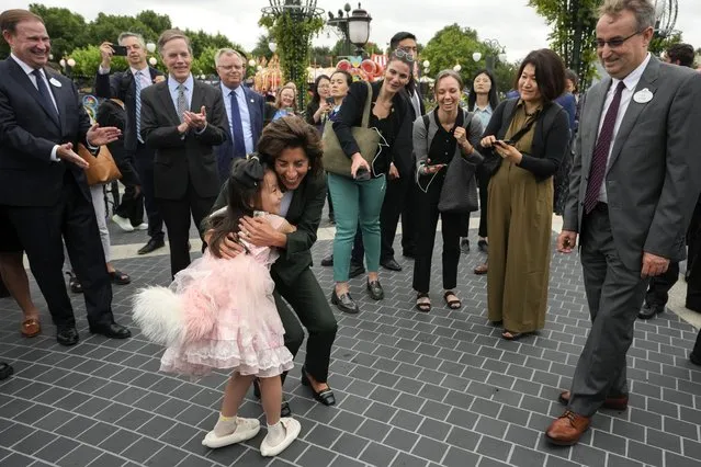 U.S. Commerce Secretary Gina Raimondo, center, hugs a young girl dressed in LinaBell costume as she tour the Shanghai Disneyland in Shanghai, China, Wednesday, August 30, 2023. (Photo by Andy Wong/AP Photo)