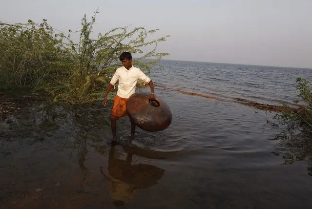 A youth walks with a floating pitcher, which he uses to catch fish in Soneri village next to Keenjhar Lake, near Thatta, February 22, 2015. (Photo by Akhtar Soomro/Reuters)