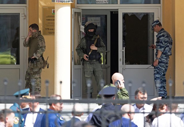 Law enforcement officers stand next to the entrance of School Number 175 after a deadly shooting in Kazan, Russia May 11, 2021. At least nine people, most of them children, were killed on May 11, 2021 when a lone teenage gunman opened fire at a school in the central Russian city of Kazan, officials said. (Photo by Artem Dergunov/Reuters)