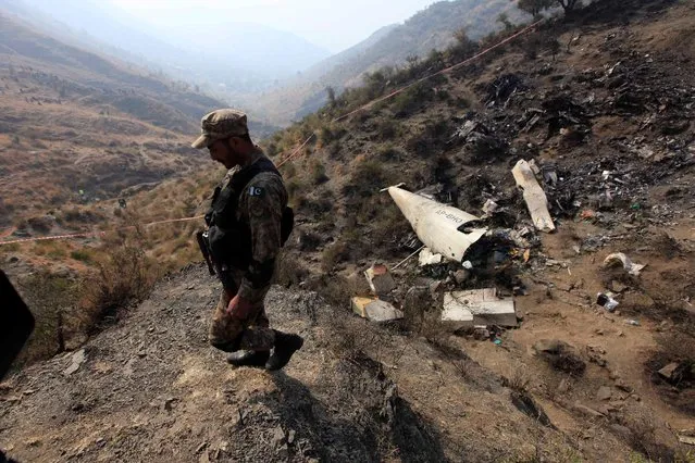 A Pakistani soldier walks near the wreckage of a Pakistan International Airline (PIA) plane, which crashed a day earlier, in the village of Saddha Batolni near Abbotabad, Pakistan December 8, 2016. (Photo by Faisal Mahmood/Reuters)