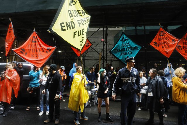 Climate activists protest outside the Federal Reserve Bank of New York to call for an end to the use of fossil fuels, Monday, September 18, 2023, in New York. (Photo by Jason DeCrow/AP Photo)