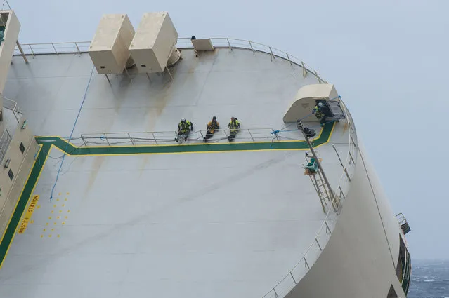This handout picture taken on January 30, 2016 and obtained from the Marine Nationale (French Navy) on February 1, 2016 shows experts aboard the Panamanian-registered cargo ship “Modern Express”, which has been drifting since January 26 in the Atlantic Ocean off the western coast of France. A new and last towing attempt began on February 1 according to French authorities. (Photo by Loic Bernardin/AFP Photo)