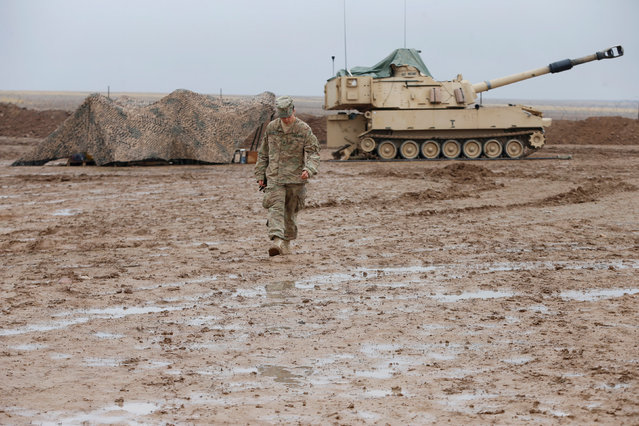 A U.S. soldier walks in front of a tank at an army base in Karamless town, east of Mosul, Iraq, December 25, 2016. (Photo by Ammar Awad/Reuters)