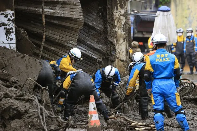 Police officers continue a search operation for missing people at the site of a mudslide in Atami, southwest of Tokyo Tuesday, July 6, 2021. Rescue workers struggled with sticky mud and risks of more mudslides Tuesday as they searched for people may have been trapped after a torrent of mud that ripped through a seaside hot springs resort. (Photo by Kyodo News via AP Photo)