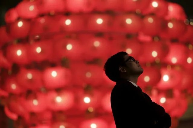 A man watches firecrackers and fireworks during celebrations for the start of the Chinese Lunar New Year of Monkey in Beijing early February 8, 2016. (Photo by Damir Sagolj/Reuters)