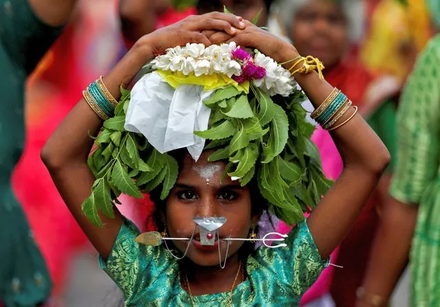 A Hindu devotee takes part in paal kuda pavani (Milk Offering) which is kept and carried on the head, to be offered to Lord Murugan at a Hindu temple, in Colombo, Sri Lanka on July 22, 2023. (Photo by Dinuka Liyanawatte/Reuters)