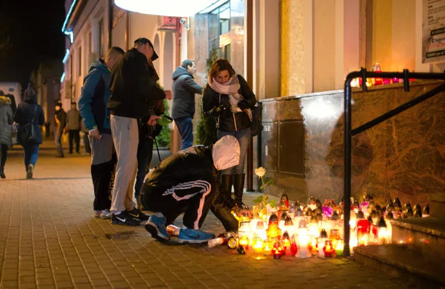 A man lays a candle in front of the kebab shop where a 21-year old man was stabbed to death during new year's eve in a brawl with shop workers, in Elk, Poland on January 2, 2017. The incident was followed by violent protests by the locals who threw bricks and stones at the shop after rumours that the workers were of Tunisian nationality. (Photo by Arkadiusz Stankiewicz/Reuters/Agencja Gazeta)