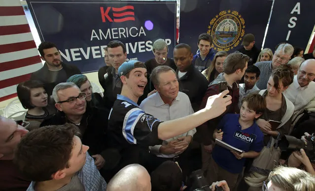 Peter Tsipis of Wayland, Mass., left, snaps a selfie with Republican presidential candidate, Ohio Gov. John Kasich during a campaign stop in Nashua, N.H., Sunday, February 7, 2016. Tipis traveled New Hampshire to hear Kasich in person. (Photo by Charles Krupa/AP Photo)