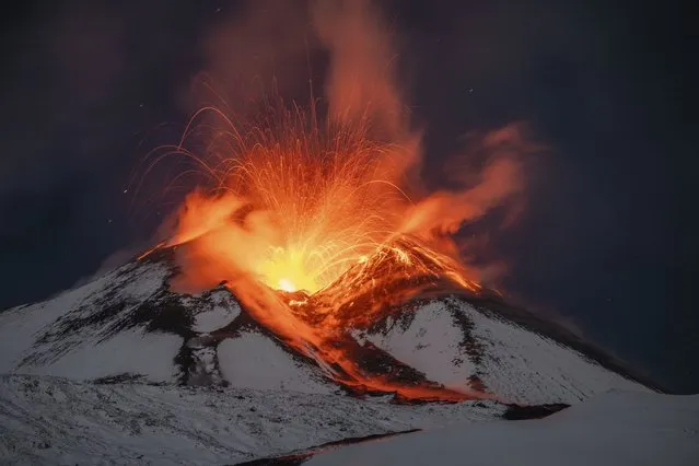 Lava erupts from snow-covered Mt Etna volcano, Sicily, Italy, early Saturday, November 25, 2023. Europe's most active volcano remains active scattering ashes around a vastly populated area on its slopes. (Photo by Etnawalk, Giuseppe Di Stefano/AP Photo)