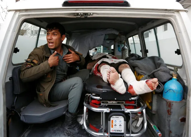 An Afghan police officer sits next to an injured person inside an ambulance after a suicide attack in Kabul, Afghanistan January 10, 2017. (Photo by Mohammad Ismail/Reuters)