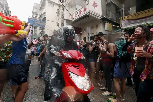 Revellers splash water onto passing motorists during Songkran Festival celebrations at Kowloon City district is known as Little Thailand as there is large number of restaurants and shops run by Thais April 12, 2015. (Photo by Tyrone Siu/Reuters)