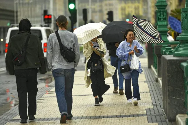 People shelter from the rain under their umbrellas, in San Sebastian, northern Spain, Thursday, November 2, 2023. Authorities have announced heavy rain and wind for next few days along the country. (Photo by Alvaro Barrientos/AP Photo)