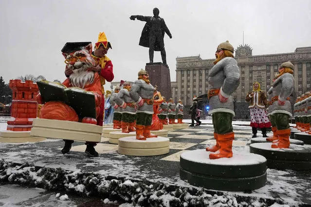 Street actors play chess with huge chessmen made in the form of characters from fairy tales written by the famous Russian poet Alexander Pushkin, at a Christmas market opened prior to incoming Christmas and New Year festivities in St. Petersburg, Russia, Friday, December 22, 2023, with a statue of Soviet Union founder Vladimir Lenin in the background. (Phoot by Dmitri Lovetsky/AP Photo)