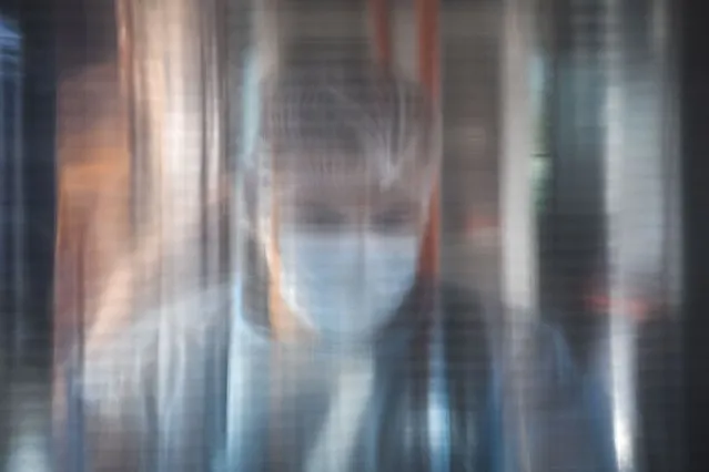 A medical worker is seen through a plastic panel in a bus that will serve as a mobile COVID-19 vaccination unit in Bucharest, Romania, Saturday, September 4, 2021. The inhabitants of Romania's capital will be able to get a Johnson&Johnson COVID-19 vaccine without an appointment in the latest attempt by Romanian authorities to increase vaccination rates as the number of infections is on a constant rise in the country. (Photo by Andreea Alexandru/AP Photo)
