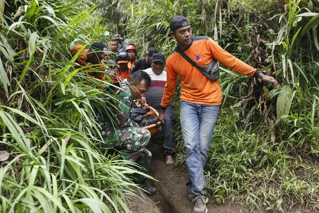 Rescuers carry away a victim after the eruption of Mount Marapi in Agam, West Sumatra, on December 4, 2023. Eleven hikers were found dead on December 4 and another 12 were missing after a volcano erupted in Indonesia, with rescuers racing to carry injured and burned survivors down the mountain on foot. (Photo by Fairuz Syaugi/AFP Photo)
