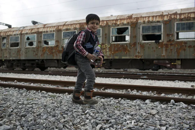 A Syrian boy walks near an abandoned wagon as he and his family approach the Greek border station of Idomeni on Friday, February 26, 2016. About 4000 people are stranded at the Greek Macedonian border, authorities said. (Photo by Petros Giannakouris/AP Photo)