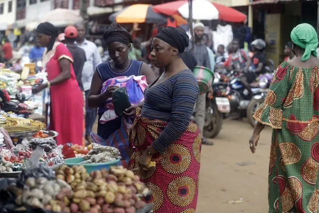 Women shop at Kaporo market in Conakry, Guinea, Monday, September 13, 2021. (Photo by Sunday Alamba/AP Photo)