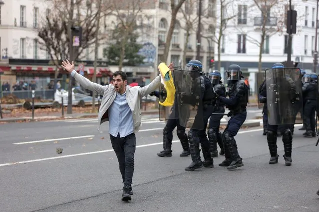 A member of the Kurdish community tries to calme demonstrator during clashes with police officers during a protest against the recent shooting at the Kurdish culture center in Paris, Saturday, December 24, 2022. Kurdish activists, left-wing politicians and anti-racism groups are holding a protest Saturday in Paris after three people were killed at a Kurdish cultural center in an attack aimed at foreigners. (Photo by Lewis Joly/AP Photo)