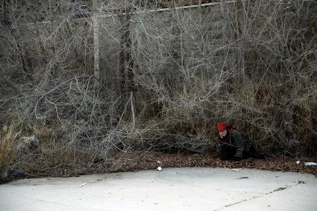 A woman hides from zombies as she participates in an event to promote the Spanish release of the movie “Resident Evil: The Final Chapter” in Madrid, Spain, January 28, 2017. (Photo by Susana Vera/Reuters)