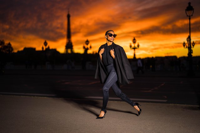 A blazing sunset behind the Eiffel Tower provides a dramatic backdrop for the model Emilie Joseph @in_fashionwetrust during a fashion shoot featuring items by Frankie Shop and Thierry Mugler on October 17, 2021 in Paris, France. (Photo by Edward Berthelot/Getty Images)