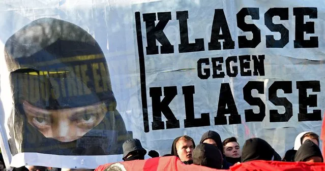 Masked protestors are seen in front of a banner, which reads “Class against Class” during a May Day march in Hamburg, Germany, May 1, 2015. (Photo by Fabian Bimmer/Reuters)