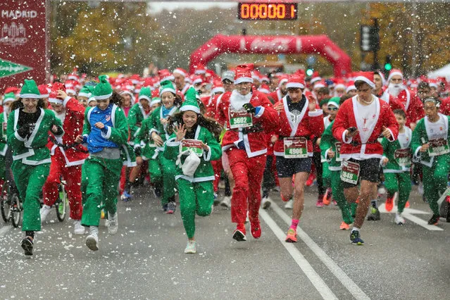 People wearing Santa Claus outfits take part in a charity race to collect funds to help vulnerable families raising children, in Madrid, Spain on December 18, 2022. (Photo by Isabel Infantes/Reuters)