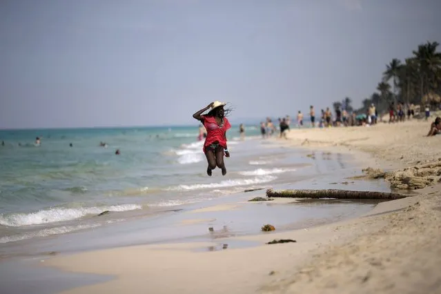A woman jumps in the air while posing for a photograph at the beach in Santa Maria, on the outskirts of Havana, March 18, 2016. (Photo by Ueslei Marcelino/Reuters)