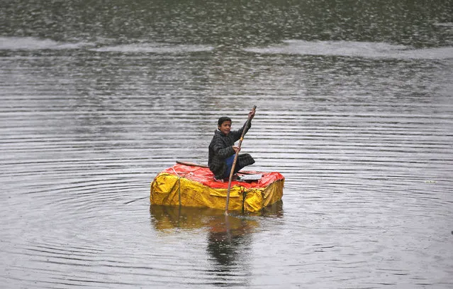A boy rows a makeshift boat in a canal during rains in Srinagar, India March 11, 2016. (Photo by Danish Ismail/Reuters)