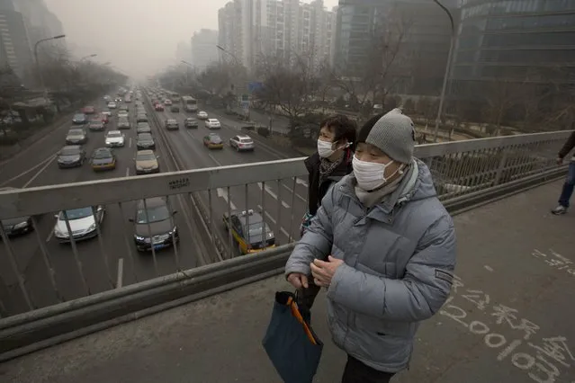 Pedestrians cross an overhead bridge as vehicles clog a main highway during a sixth straight day of severe pollution in Beijing Tuesday, February 25, 2014. Hazardous white pollution hid much of Beijing's skyline Tuesday, despite announced closures or production cuts at 147 of the city's industrial plants. (Photo by Ng Han Guan/AP Photo)