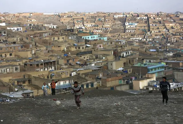 A group of boys play football on a hilltop overlooking Kabul March 4, 2014. (Photo by Mohammad Ismail/Reuters)