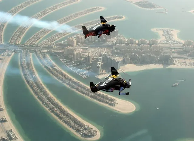 An aerial view taken from a sea plane shows Swiss pilot and original Jetman Yves Rossy (front) and Vince Reffett flying over Dubai's Palm Island, United Arab Emirates May 12, 2015. (Photo by Lara Sukhtian/Reuters)