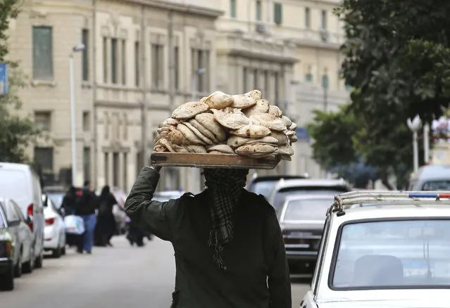 A man carries freshly baked bread on his head along a street in Cairo, Egypt, February 8, 2016. (Photo by Asmaa Waguih/Reuters)