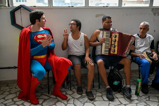 Leonardo Muylaert, 36, known as the Brazilian Superman, talks with a group of patients of the Association of Parents and Friends of Neurodivergent People (APAE-RIO) in the Tijuca neighborhood in Rio de Janeiro, Brazil, on March 18, 2024. Muylaert, a lawyer who didn’t have social media one year ago, found out a video of him visiting an event went viral on TikTok, calling him the “Brazilian Superman”. He liked the idea and jumped on a Superman costume, and since then, he has been traveling around Brazil as Superman. (Photo by Mauro Pimentel/AFP Photo)