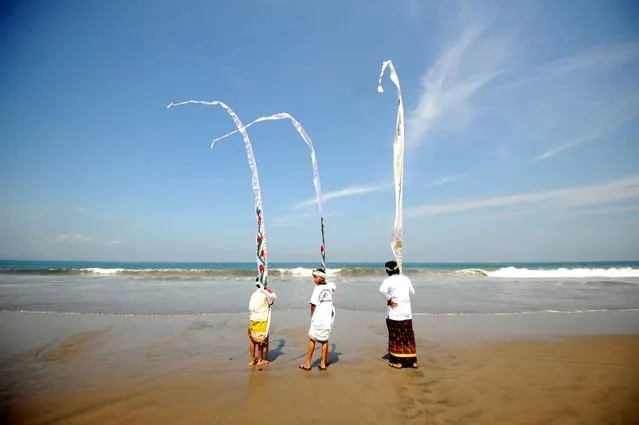 Balinese people attend a Melasti prayer ceremony at Petitenget beach in Kuta on Indonesia's resort island of Bali on March 28, 2014. (Photo by Sonny Tumbelaka/AFP Photo)