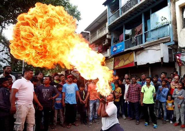A Hindu devotee performs a stunt with fire during a rehearsal ahead of the annual Rath Yatra, or chariot procession, in Ahmedabad, India, June 30, 2019. (Photo by Amit Dave/Reuters)