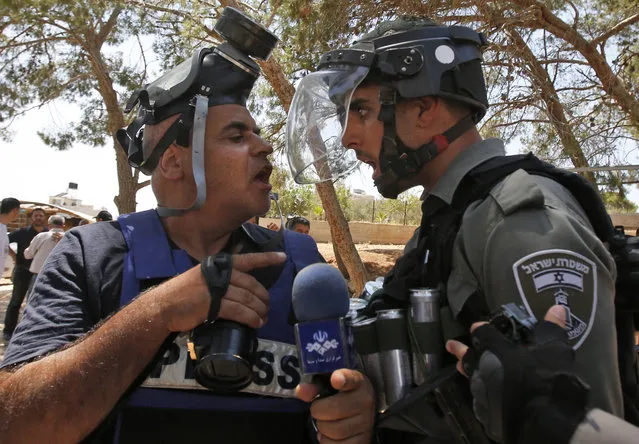 A picture taken in Dar Salah on August 2, 2019, shows an Israeli border police confronting a journalist following clashes after the friday prayers at the site of demolished buildings in the West Bank, adjacent to the area of Sur Baher in East Jerusalem. (Photo by Musa Al Shaer/AFP Photo)