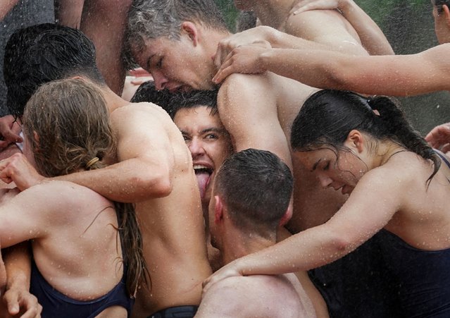 Members of U.S. Naval Academy's first year class climb the Herndon Monument, in a ritual marking the end of their plebe year in Annapolis, Maryland on May 15, 2024. (Photo by Kevin Lamarque/Reuters)