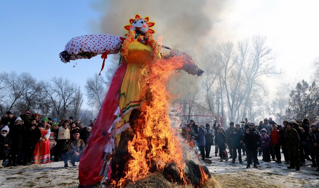 Russian people watch the burning of an effigy of Maslenitsa during the celebration of Maslenitsa in the village of Leninskoe, 30 km from Bishkek, Kyrgyzstan, 26 February 2023. Maslenitsa holiday, celebrating the end of winter,  originates from ancient Slavic mythology and is usually celebrated in the last week before Lent. (Photo by Igor Kovalenko/EPA/EFE/Rex Features/Shutterstock)