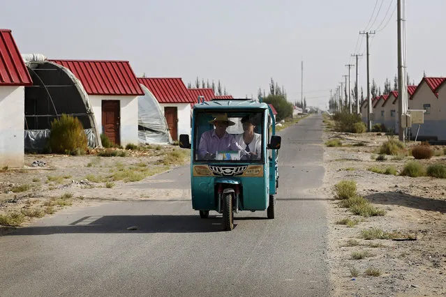 In this September 21, 2018, photo, Han Chinese ride in a tricycle passing by farmhouses at the Unity New Village in Hotan, in western China's Xinjiang region. The Trump administration, locked in a trade war with China, is increasing the pressure on Beijing over what it says is the systematic oppression of ethnic minority Muslims. American officials hosted a panel Tuesday, Sept. 24, 2019, on the sidelines of the United Nations General Assembly gathering in New York to highlight the plight of Uighurs, whose native land in China’s far western Xinjiang province they say is a police state. (Photo by Andy Wong/AP Photo)