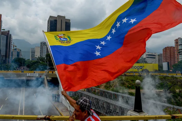 A demonstrator waves a Venezuelan national flag during a protest against Venezuelan President Nicolas Maduro, in Caracas on April 20, 2017. (Photo by Federico Parra/AFP Photo)