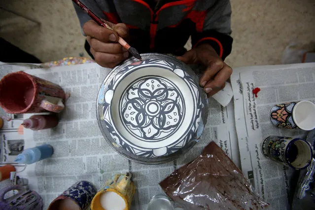 A Palestinian boy paints ceramics in Al-Okhowa pottery shop in the West Bank city of Hebron February 9, 2017. (Photo by Mussa Qawasma/Reuters)