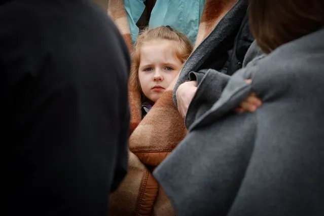 A child who fled Ukraine to Belgium following Russia's invasion, looks on while waiting outside an immigration office in Brussels, Belgium, 15 March 2022. The first temporary reception center in Belgium for people who fled Ukraine has been closed due to low reception capacity. A new center with higher capacity has been opened at Palais 8 on the Heyzel plateau. According to figures released by the United Nations High Commissioner for Refugees (UNHCR), over 2.9 million refugees have fled Ukraine since Russia began its military invasion on 24 February. (Photo by Stephanie Lecocq/EPA/EFE)