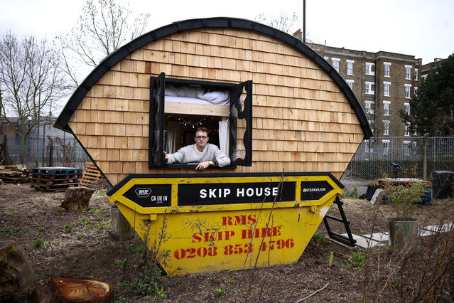 Artist Harrison Marshall poses inside the skip which he has converted into a home, where he intends to live in for a year, in Bermondsey, London, Britain on March 3, 2023. (Photo by Henry Nicholls/Reuters)