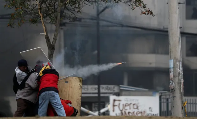 Demonstrators fire a homemade weapon during a protest against Ecuador's President Lenin Moreno's austerity measures, in Quito, Ecuador on October 13, 2019. (Photo by Ivan Alvarado/Reuters)
