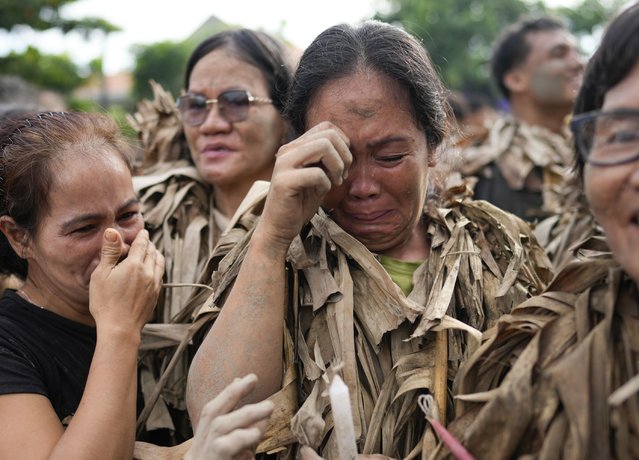 Devout Catholics cry as they participate in mass at the church of Saint John the Baptist during the mud festival at Bibiclat, Nueva Ecija province, northern Philippines, Monday, June 24, 2024. (Photo by Aaron Favila/AP Photo)